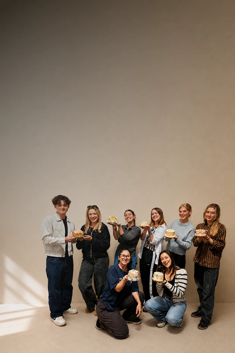 Cake workshop group holding decorated cakes