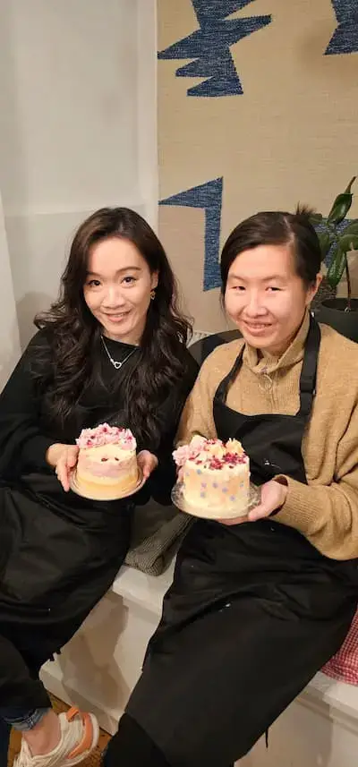 Two participants holding decorated cakes