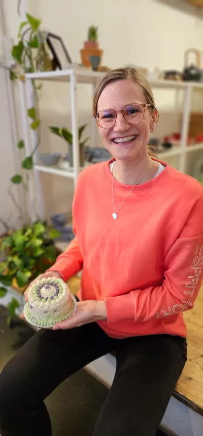 Participant holding a green buttercream cake
