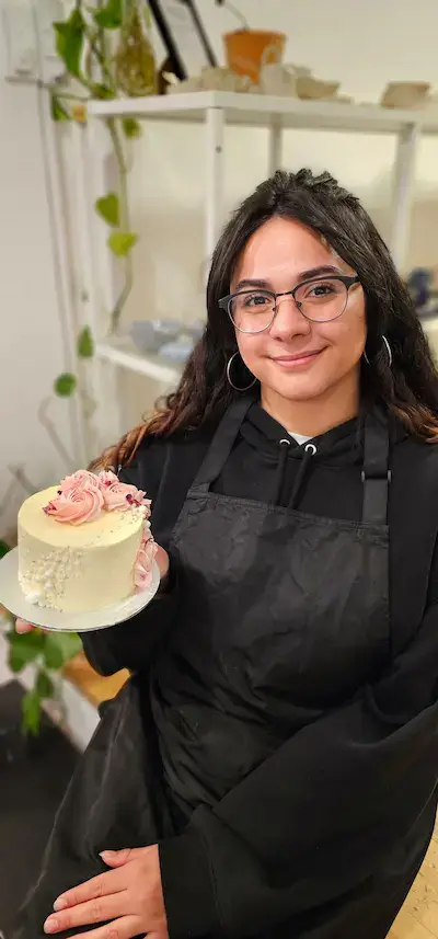 Participant holding a rose buttercream cake