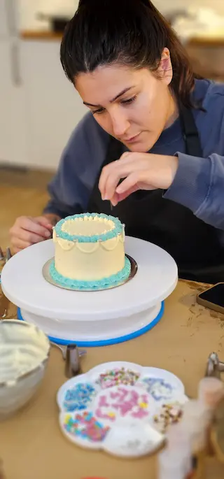 Participant decorating a blue cake