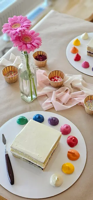 Cake decorating workshop setup with buttercream colors and sprinkles